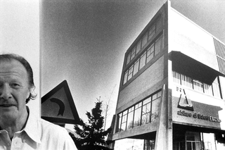 Designer e architetti, 064-064-14
L'architetto Belotti ritratto davanti a una fotografia della sede di Abitare Baleri ad Albino, da lui progettata, 1978
Albino (Italia)
